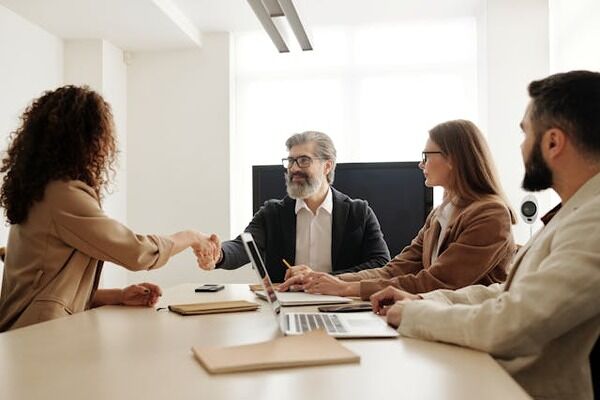 People shaking hands around a table.