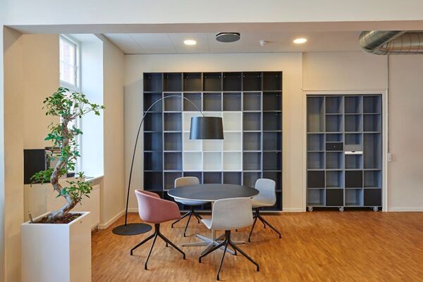 A beautiful office with a round wooden table and four chairs