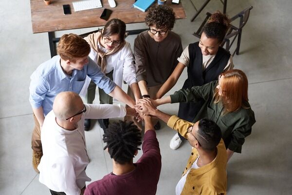 Employees holding hands together in the middle.