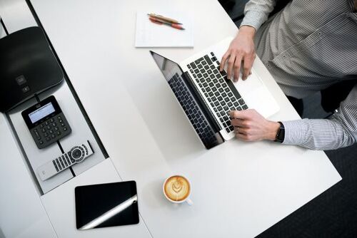 Business owner using a laptop to explore avenues for adopting innovative HR tech solutions for employee management needs.