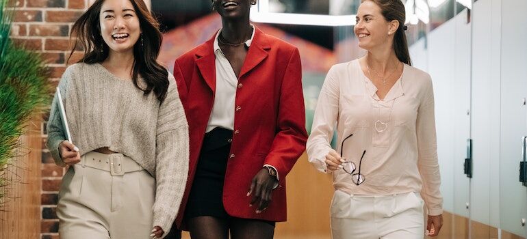 three women at work, walking and laughing