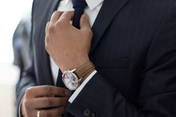 man adjusting his tie