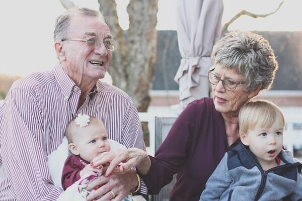 Grandparents holding their grandchildren. 