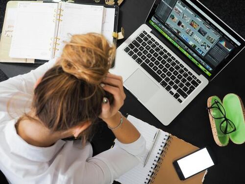 A woman working while experiencing stress.