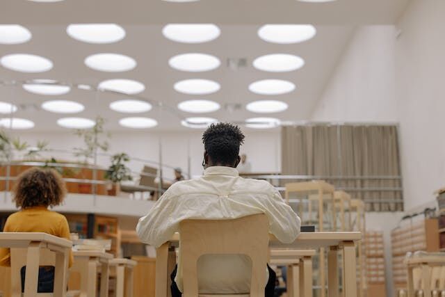 Man sitting in a library and reading