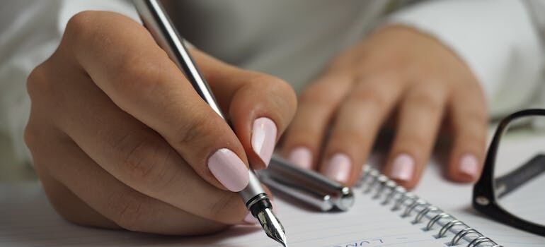 a close-up of hands writing in a notebook