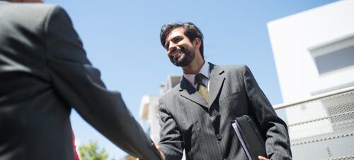 two men shaking hands, demonstrating the art of networking