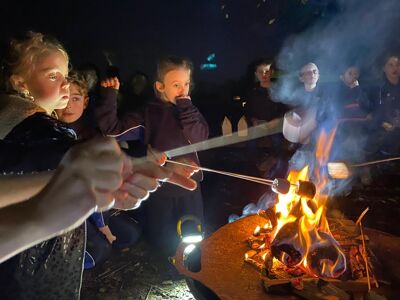 kids toasting marshmallows around the fire 